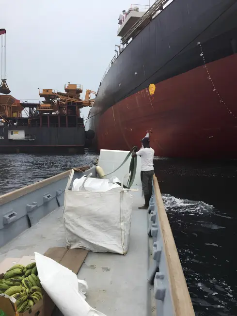Chamax Marine Services boat delivering provisions to a vessel at anchorage in Gabon