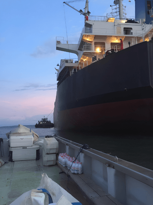 Ship supply delivery by boat at dusk — Chamax Marine Services shipchandler Libreville
