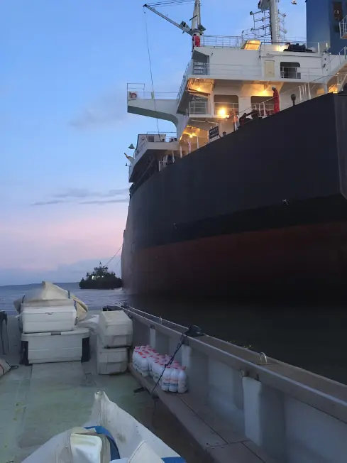Ship supply delivery by boat at dusk — Chamax Marine Services shipchandler Libreville