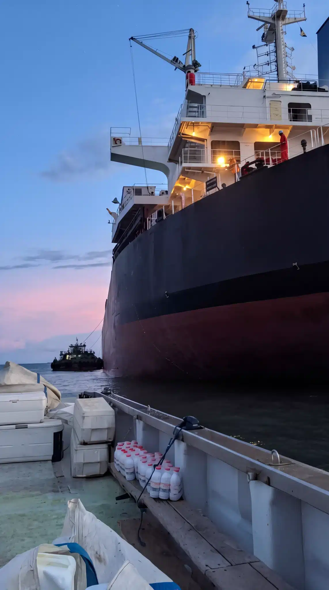 Ship supply delivery by boat at dusk — Chamax Marine Services shipchandler Libreville